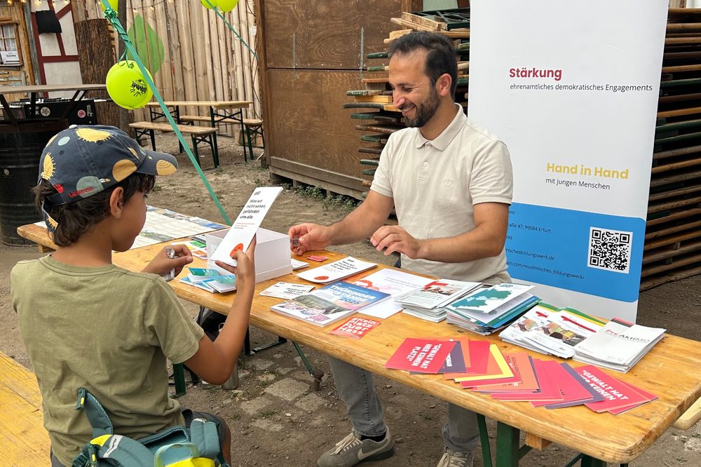 Thaer Issa im Gespräch mit einem jungen Besucher am Stand von „Jung, Demokratisch, Aktiv“