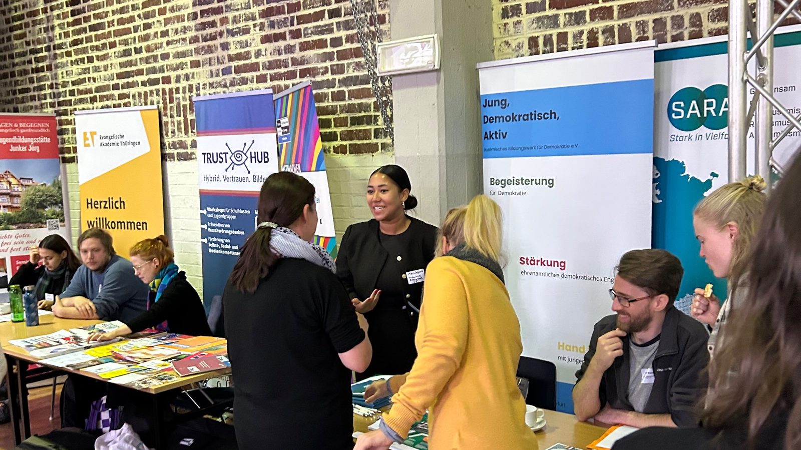 Infostand des Bildungswerks mit den Aufstellern von „Jung, Demokratisch, Aktiv“ und SARA, davor Besucherinnen im Gespräch