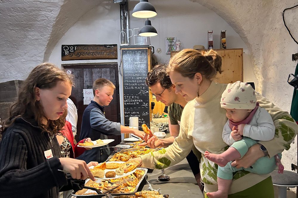 Gäste bedienen sich am Buffet mit Börek und Hummus