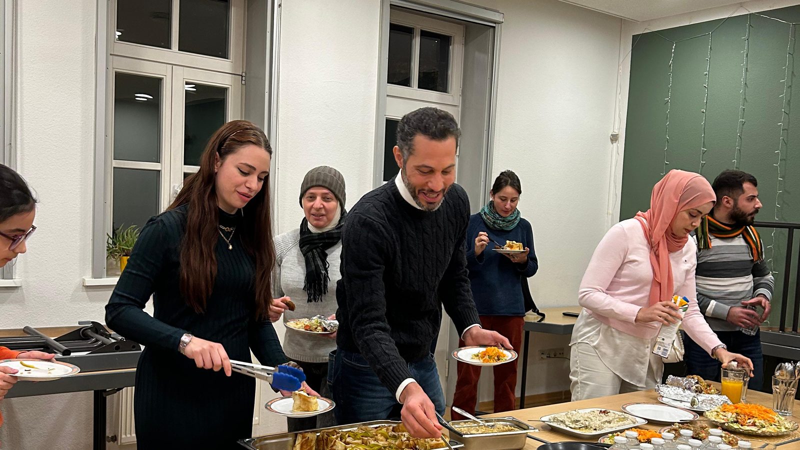 Gäste bedienen sich gut gelaunt am gemeinsamen Buffet