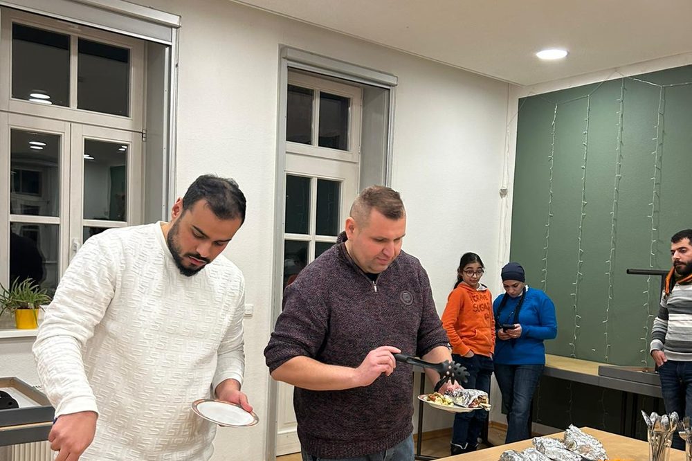 Zwei Gäste nehmen sich vom Buffet mit Wraps, Falafel und Salaten
