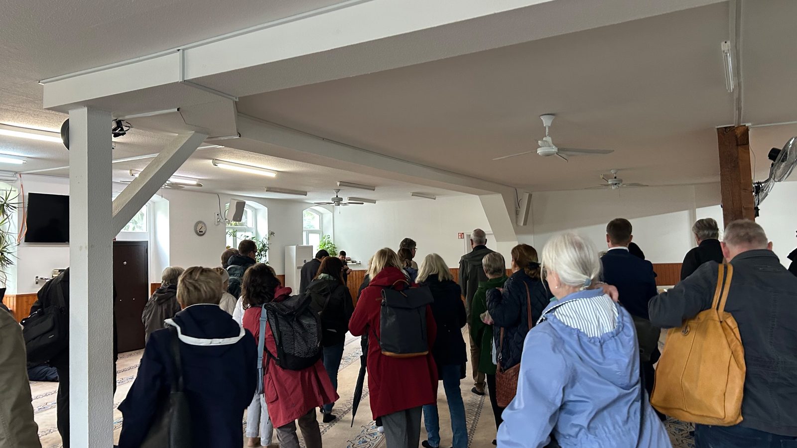 Eine Besuchergruppe betritt den Gebetsraum der Moschee
